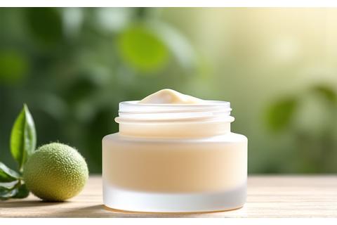 Envase de crema facial orgánica con diseño minimalista sobre un fondo claro y hojas verdes.